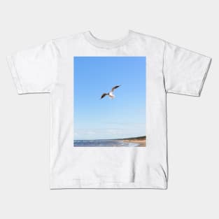 White seagull flying above the seacoast Kids T-Shirt